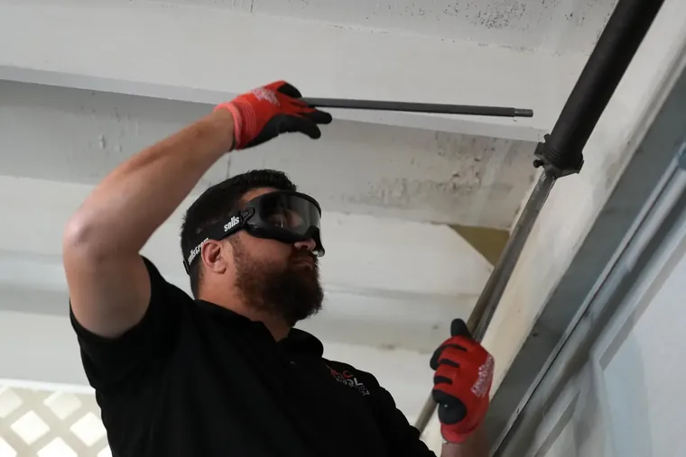 Door & Roll Garage Door technician working on a garage door torsion spring